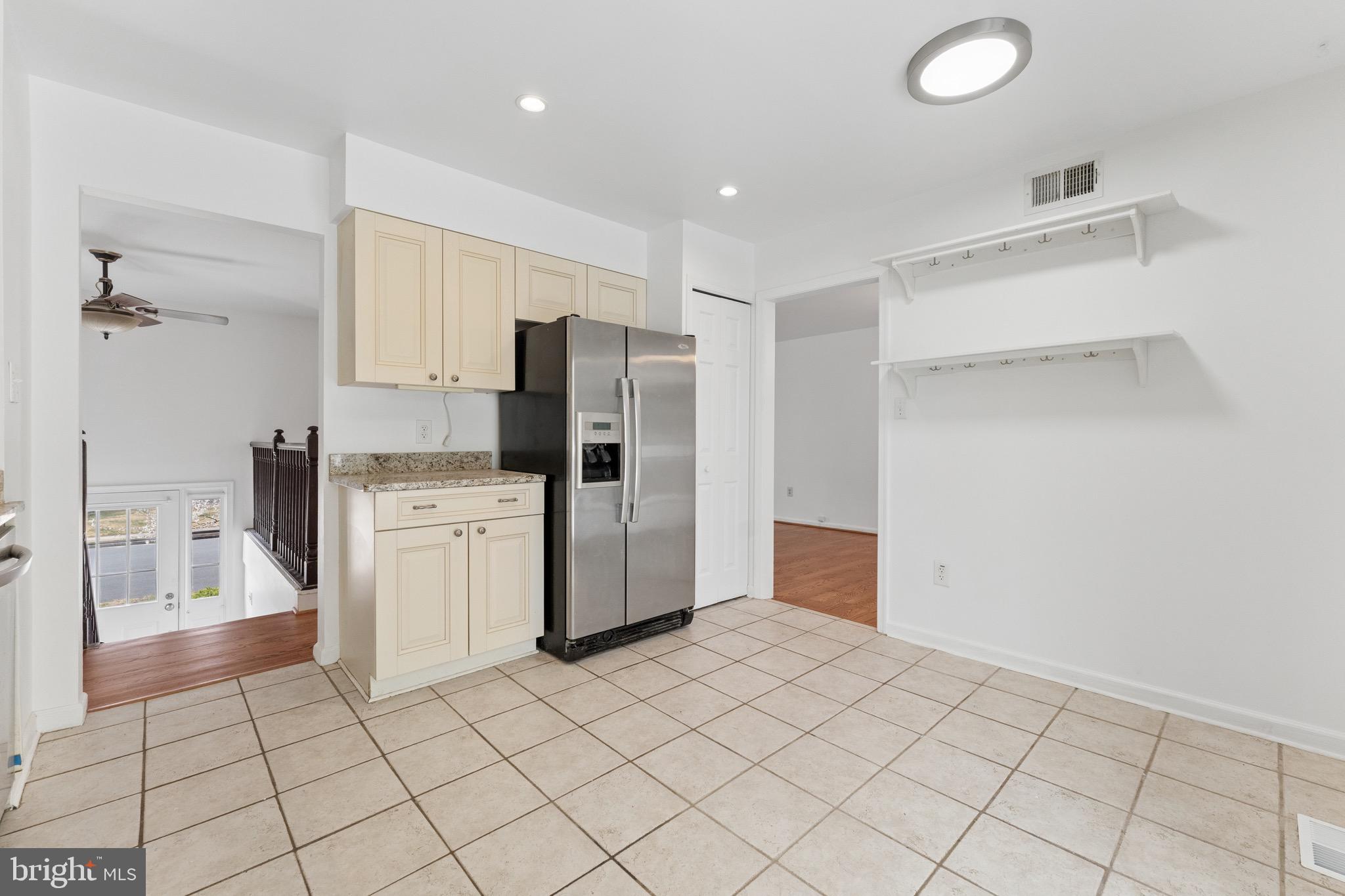 8910 Spur Road Springfield, VA 22153 - Photo 14 of 45 a kitchen with white cabinets and refrigerator