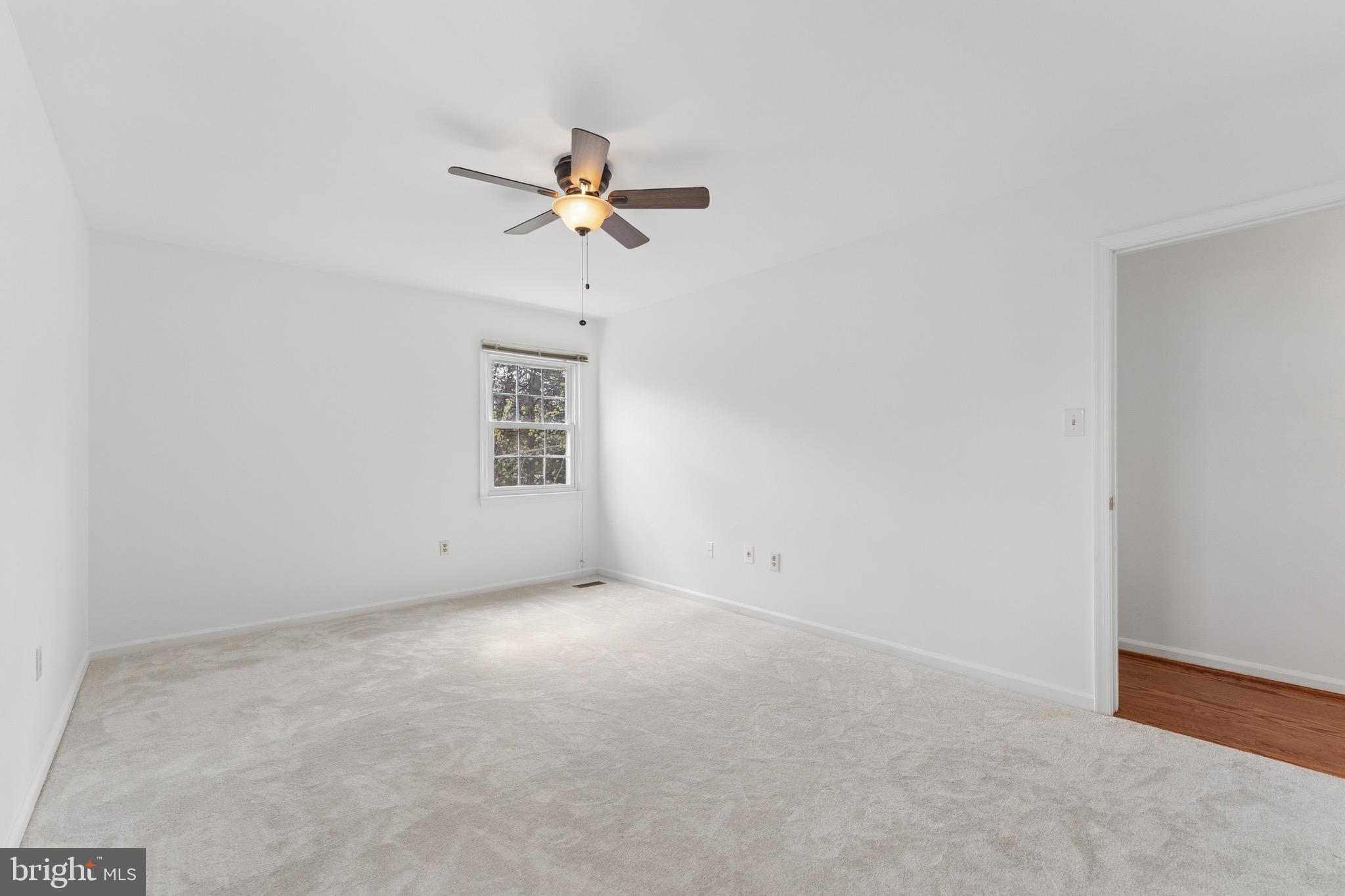 8910 Spur Road Springfield, VA 22153 - Photo 18 of 45 an empty room with a chandelier fan and windows