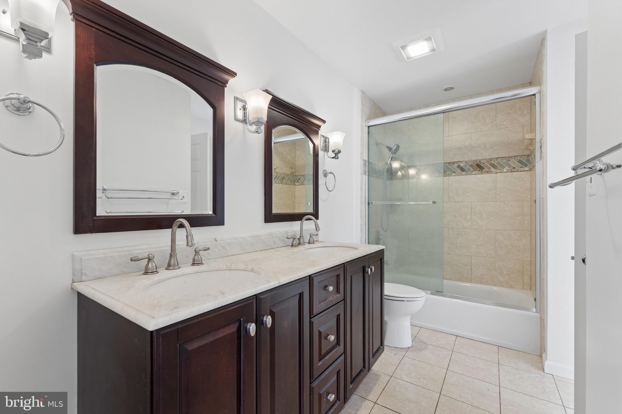 8910 Spur Road Springfield, VA 22153 - Photo 24 of 45 a bathroom with a double vanity sink mirror and shower
