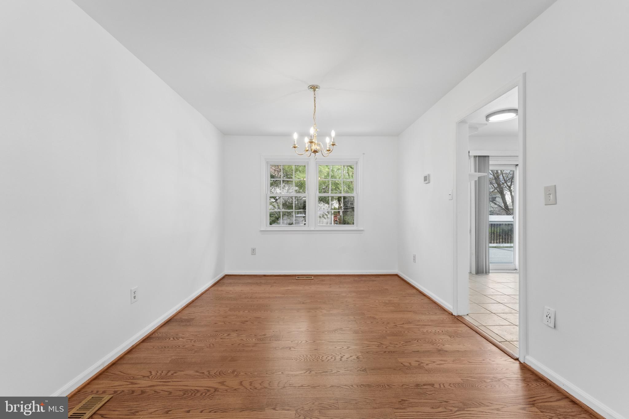 8910 Spur Road Springfield, VA 22153 - Photo 8 of 45 an empty room with windows and chandelier