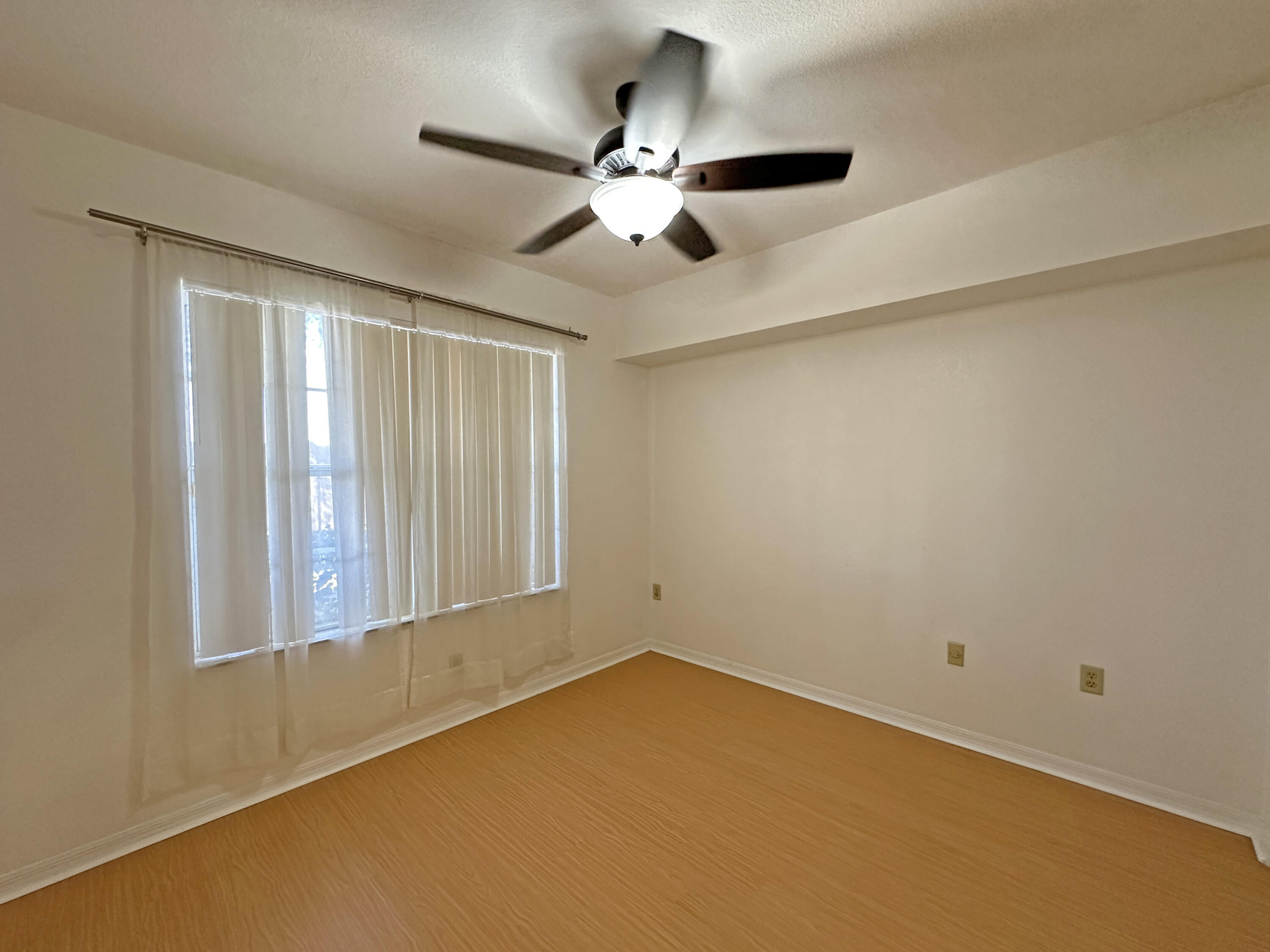 166 Southwest Peacock Boulevard, Unit 104 Port St. Lucie, FL 34986 - Photo 19 of 45 a view of an empty room with chandelier fan and a window
