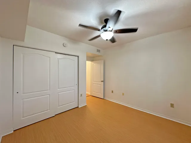 an empty room with closet and fan