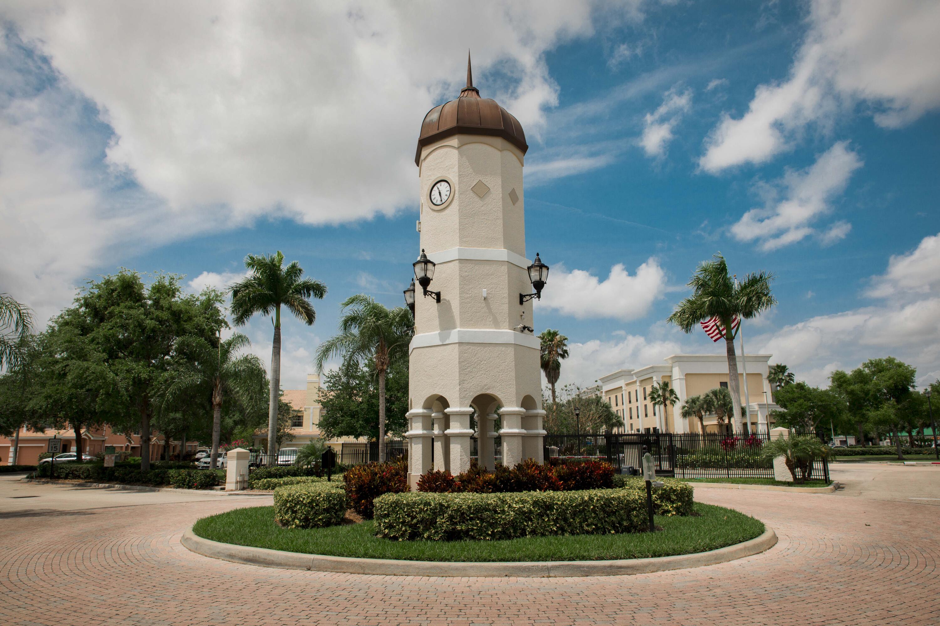 166 Southwest Peacock Boulevard, Unit 104 Port St. Lucie, FL 34986 - Photo 26 of 45 a front view of a house with a yard and trees