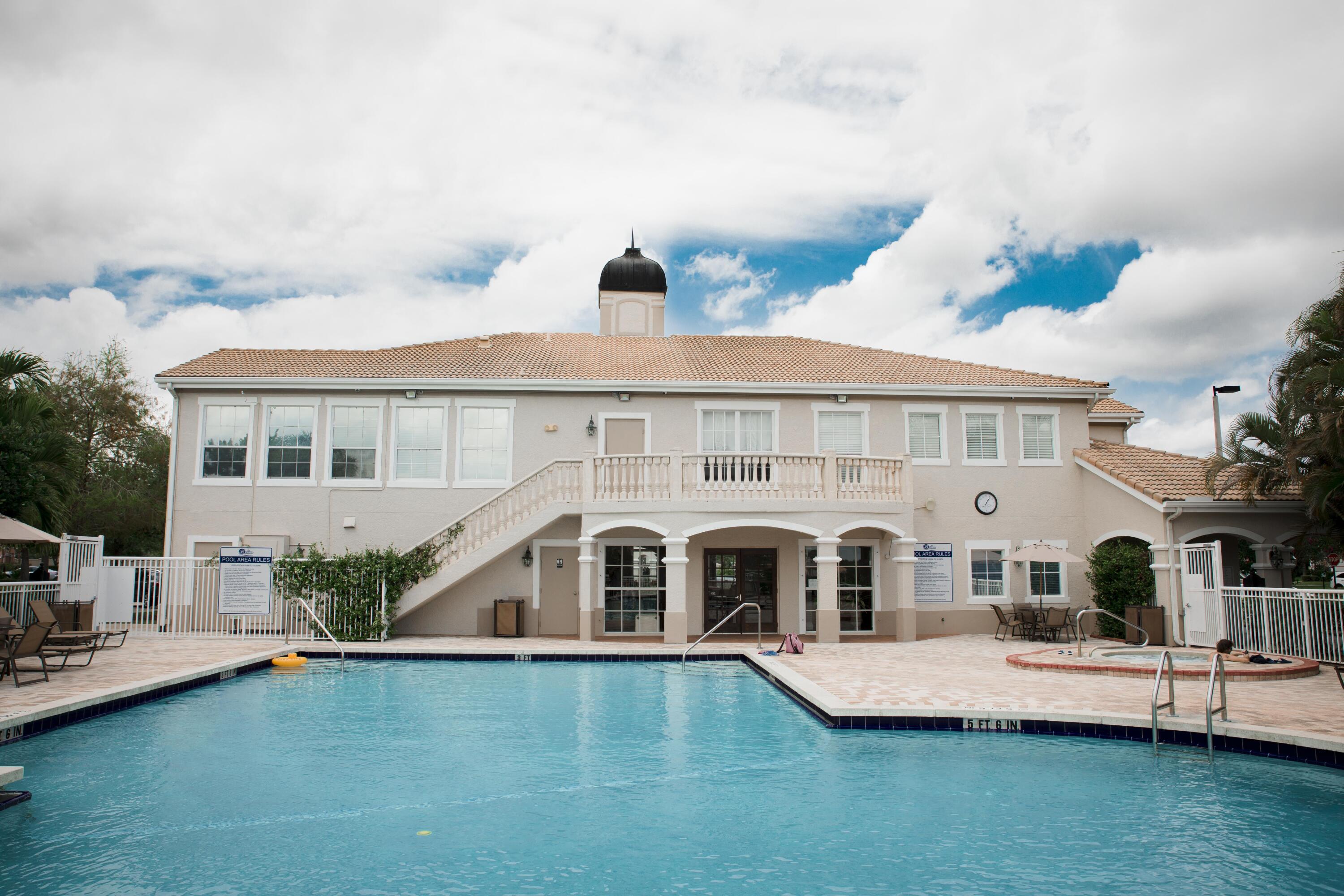 166 Southwest Peacock Boulevard, Unit 104 Port St. Lucie, FL 34986 - Photo 40 of 45 a front view of house with yard and swimming pool