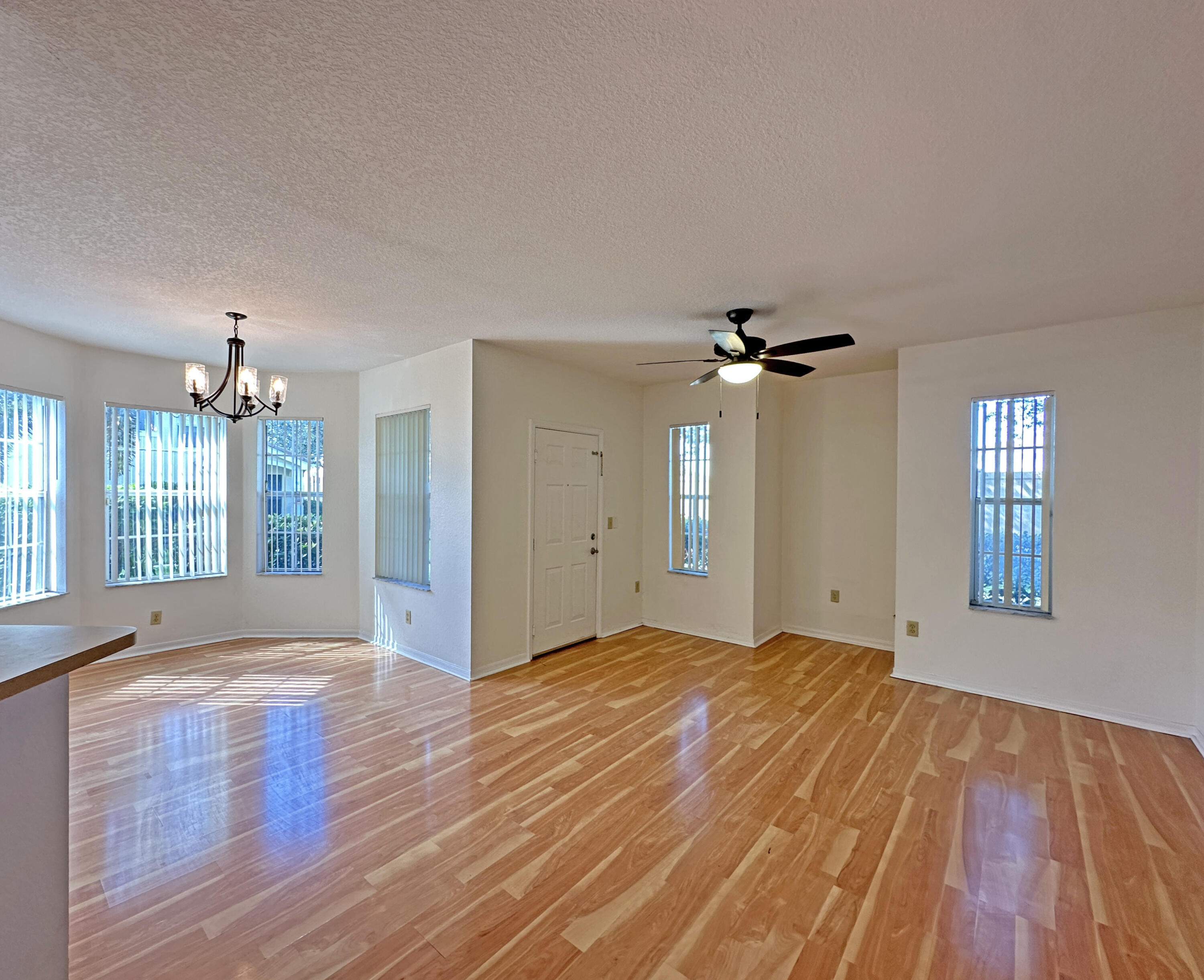 166 Southwest Peacock Boulevard, Unit 104 Port St. Lucie, FL 34986 - Photo 6 of 45 a view of an empty room with window and wooden floor