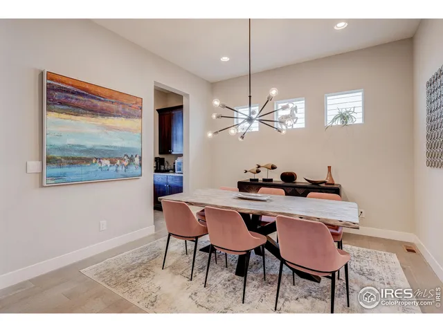 a living room with furniture a rug and white kitchen