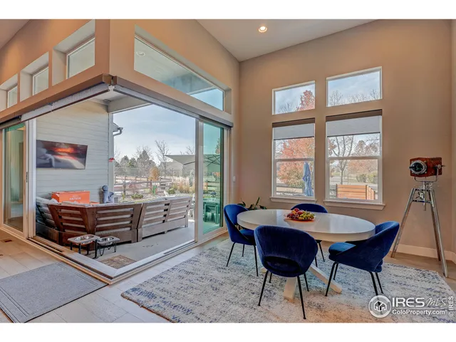 a open kitchen with stainless steel appliances granite countertop a sink a stove a refrigerator and a dining table with wooden cabinet