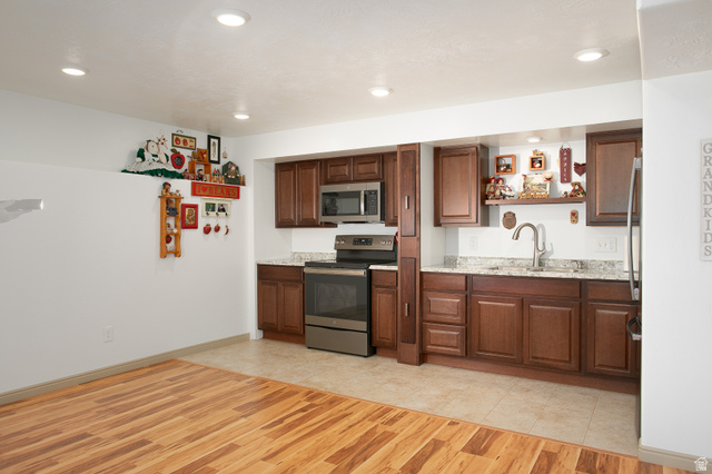 426 Deer Hollow Road Tooele, UT 84074 - Photo 22 of 37 Kitchen with appliances with stainless steel finishes, recessed lighting, light wood-type flooring, open shelves, and light stone counters