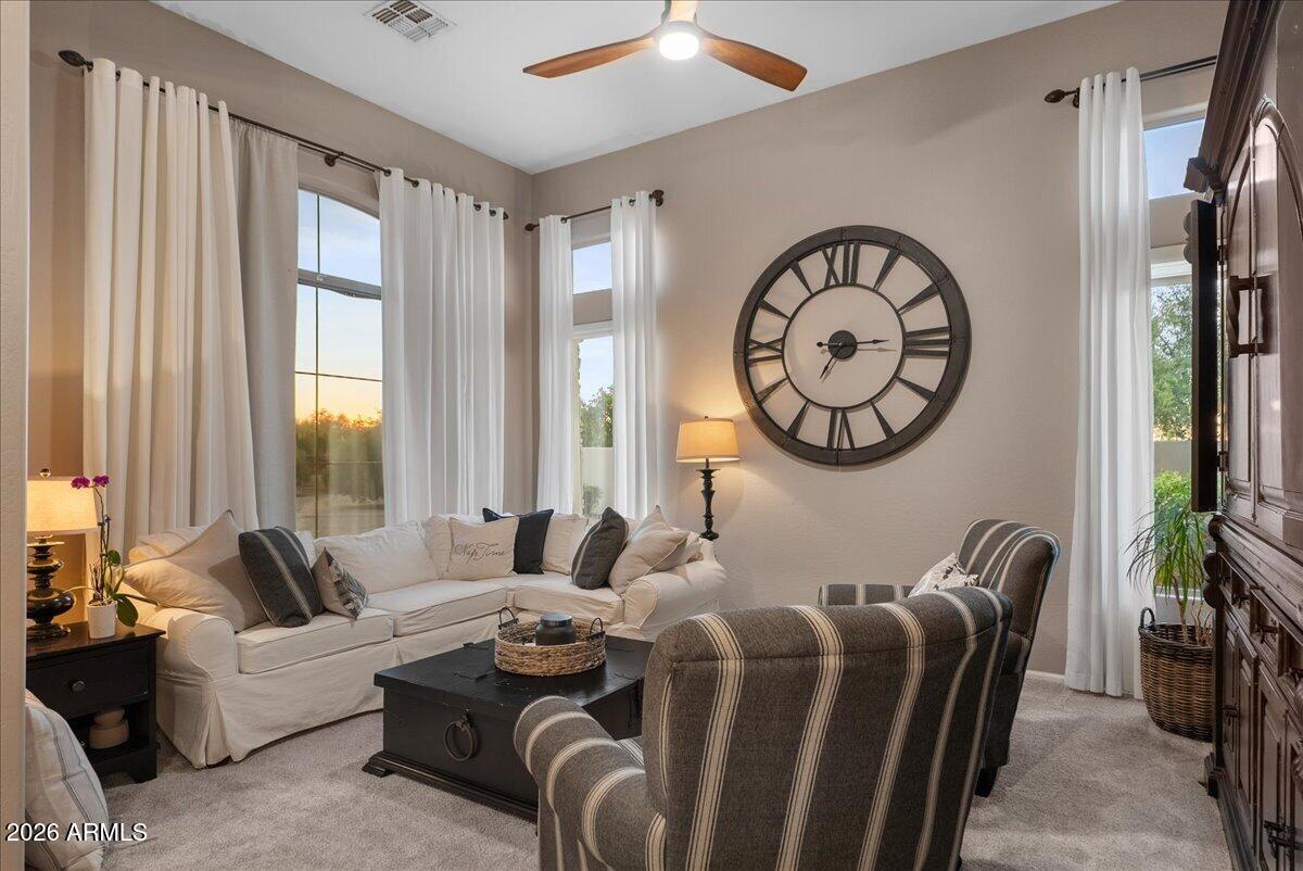 6427 South Magic Court Gilbert, AZ 85298 - Photo 6 of 71 a living room with furniture a clock and a large window