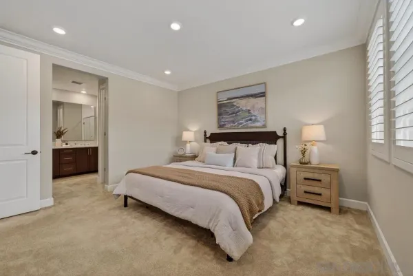 a spacious bedroom with a bed and a lamp