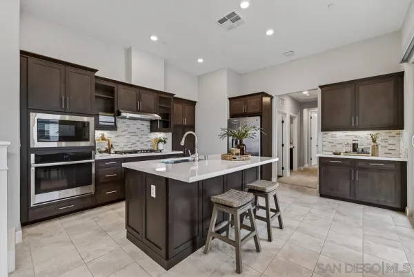 a kitchen with stainless steel appliances kitchen island granite countertop a sink counter space cabinets and stainless steel appliances