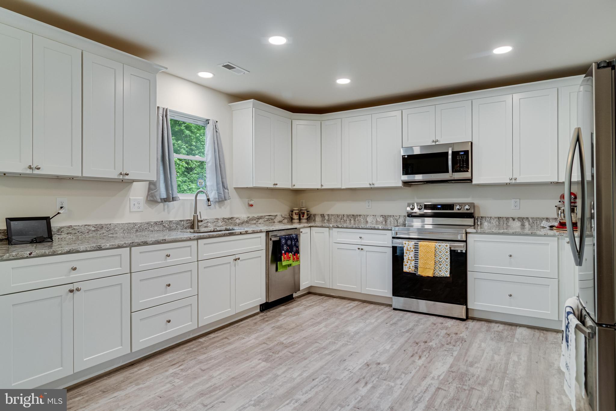 32 Placid Road Colonial Beach, VA 22443 - Photo 12 of 54 a kitchen with granite countertop white cabinets and stainless steel appliances