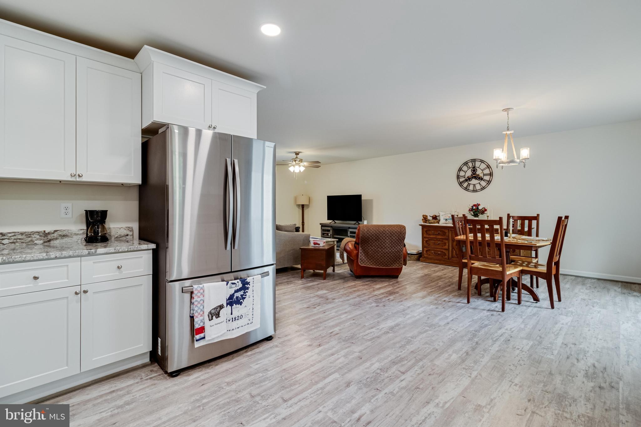 32 Placid Road Colonial Beach, VA 22443 - Photo 14 of 54 a kitchen with stainless steel appliances granite countertop a refrigerator a stove a sink a dining table and chairs with wooden floor