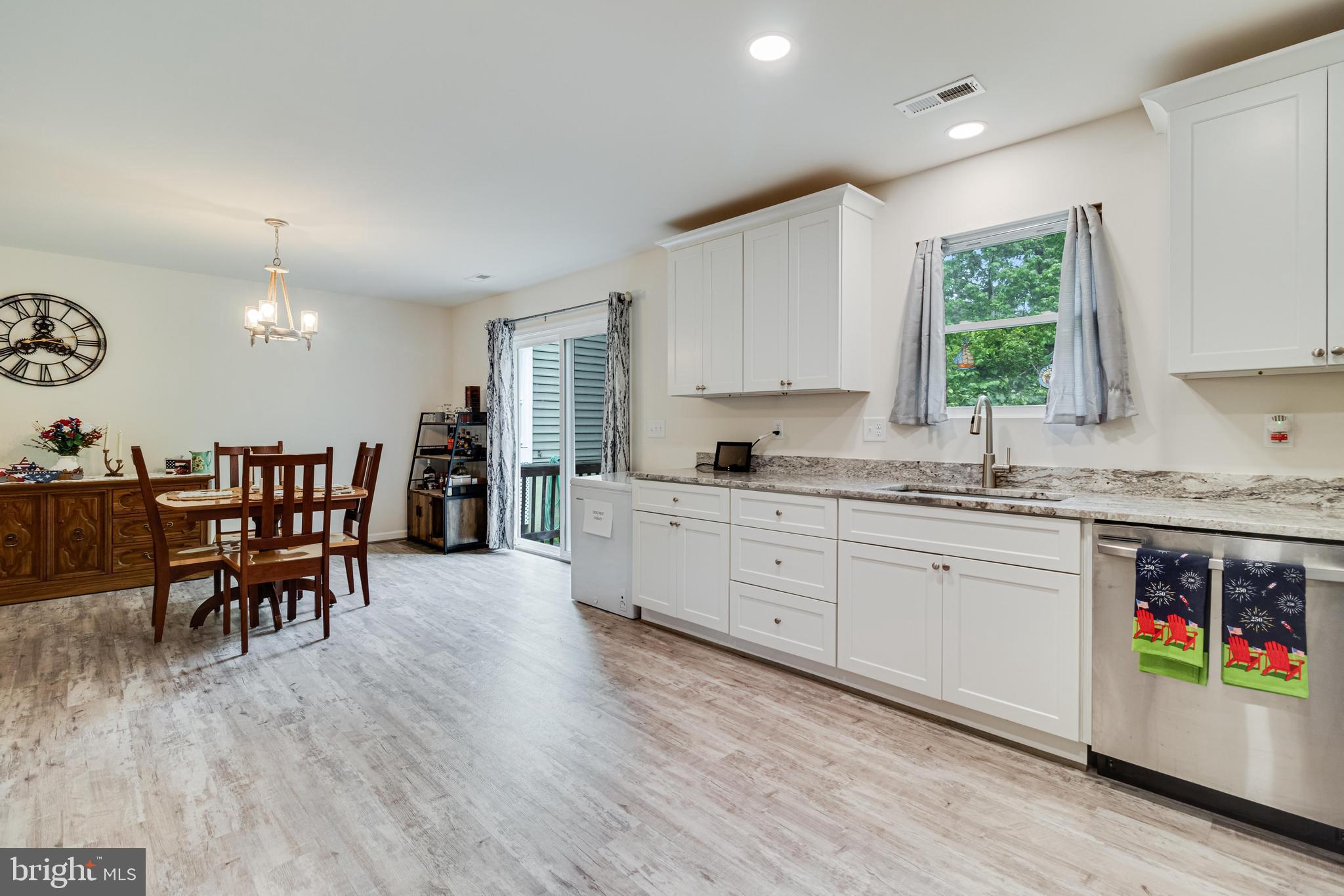 32 Placid Road Colonial Beach, VA 22443 - Photo 15 of 54 a open kitchen with stainless steel appliances granite countertop a stove a sink a dining table and chairs with wooden floor