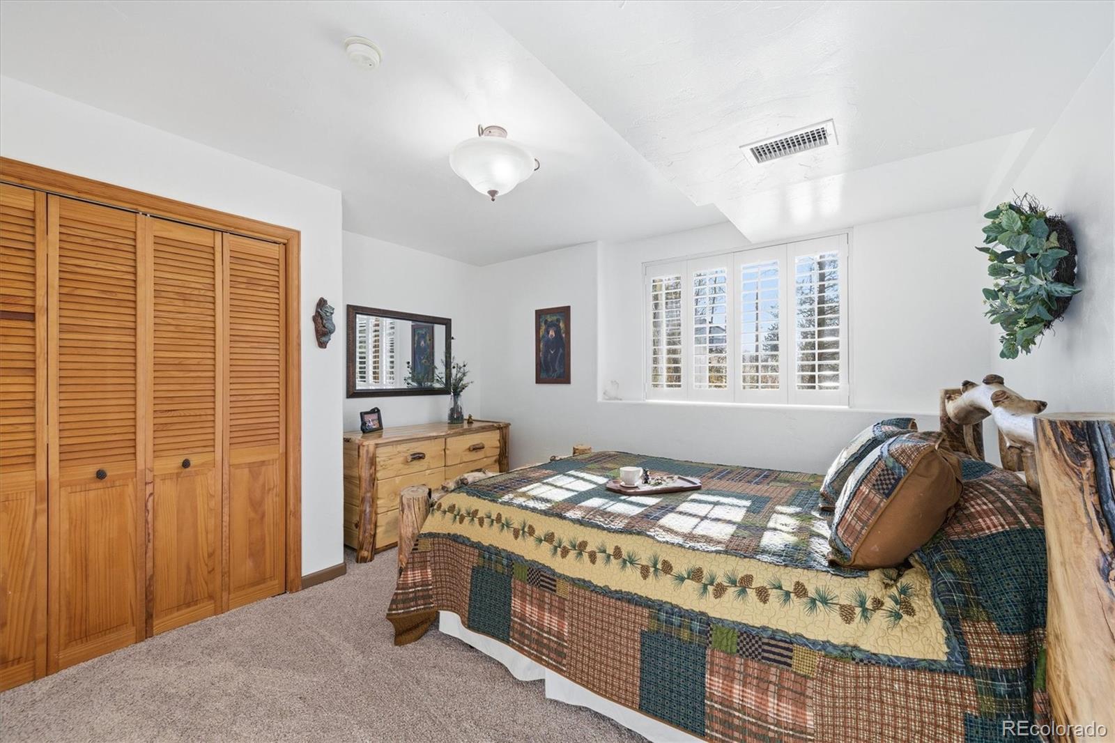 33799 Warren Road Pine, CO 80470 - Photo 33 of 50 a bedroom with a bed and wooden floor