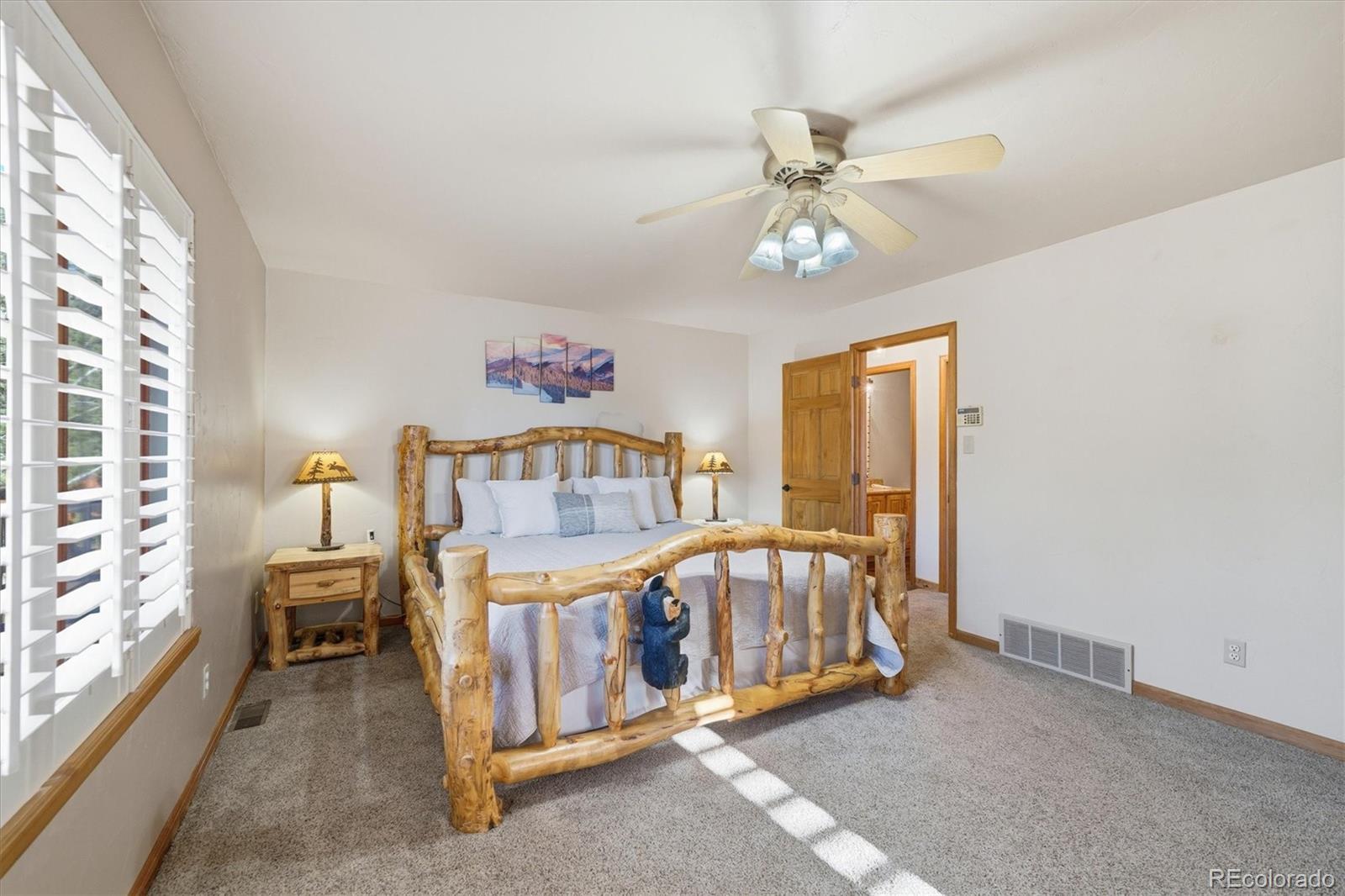 33799 Warren Road Pine, CO 80470 - Photo 39 of 50 a bedroom with a bed and a chandelier