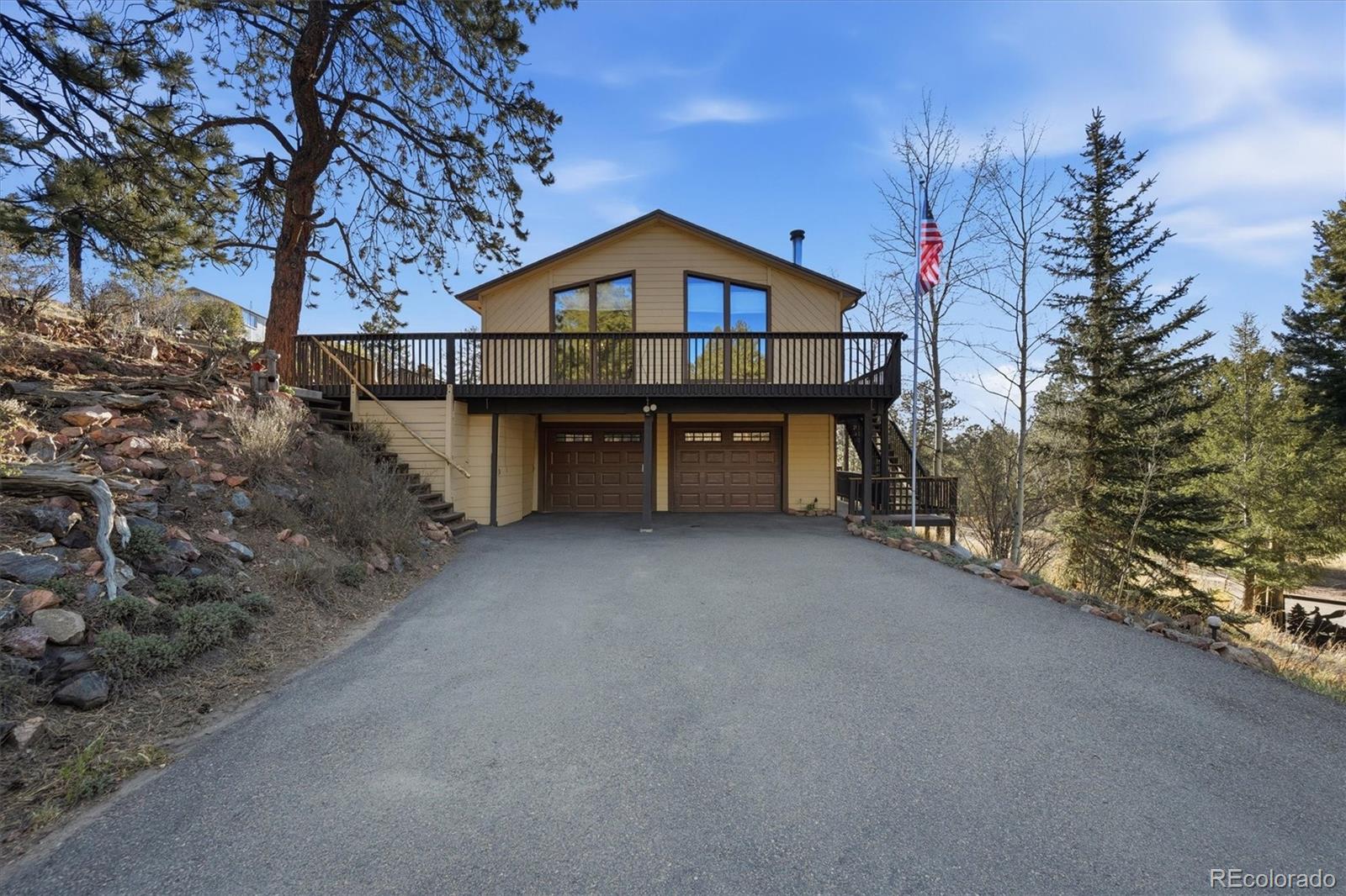 33799 Warren Road Pine, CO 80470 - Photo 5 of 50 a front view of a house with a yard and balcony