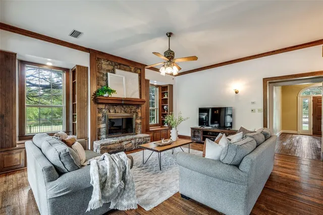 a living room with furniture a fireplace and a large window