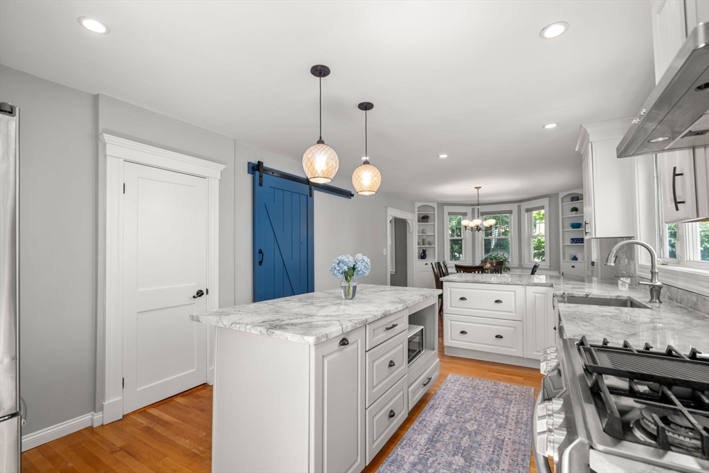 27 Frothingham Street Milton, MA 02186 - Photo 13 of 32 a very nice looking room with kitchen island a stove a sink a dining table and chairs
