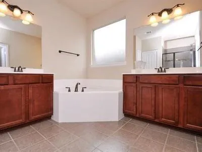 a bathroom with a bathtub sink and mirror