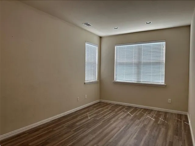 a view of a room with wooden floor and windows