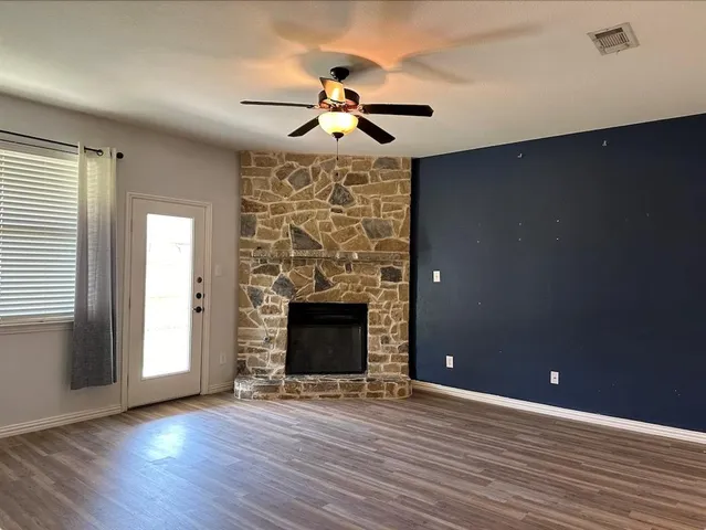 wooden floor fireplace and natural light in room