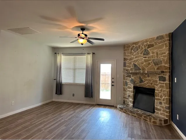 an empty room with windows and fireplace