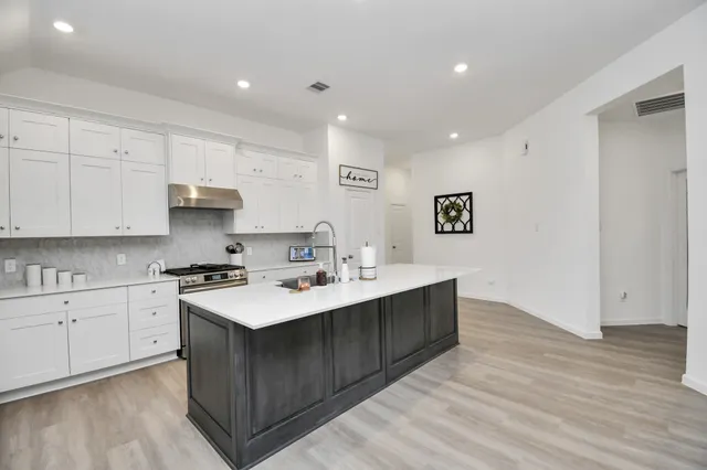 a kitchen with stainless steel appliances kitchen island sink refrigerator microwave and stove