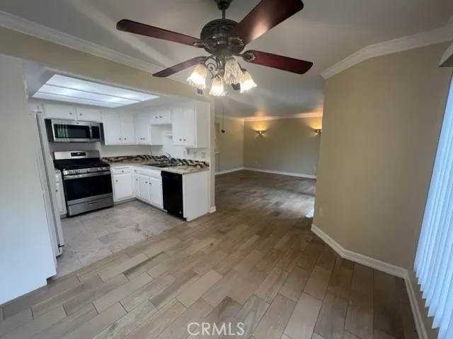 a kitchen with kitchen island granite countertop a sink cabinets and stainless steel appliances