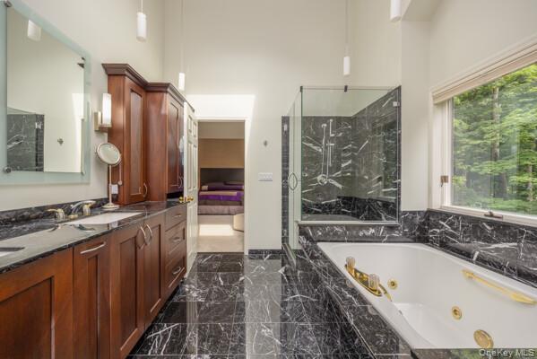 19 West Gate Road Suffern, NY 10901 - Photo 31 of 42 Bathroom featuring dark wood cabinetry, dual sinks, black veined stone countertops, and black veined stone flooring