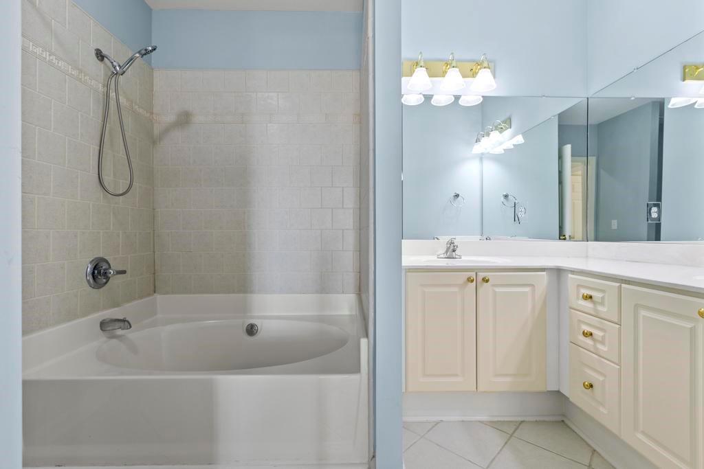 3334 Peachtree Road Northeast, Unit 1207 Atlanta, GA 30326 - Photo 15 of 25 a bathroom with a bathtub sink and a mirror