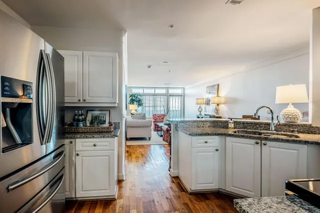 a kitchen with granite countertop a sink stove and cabinets