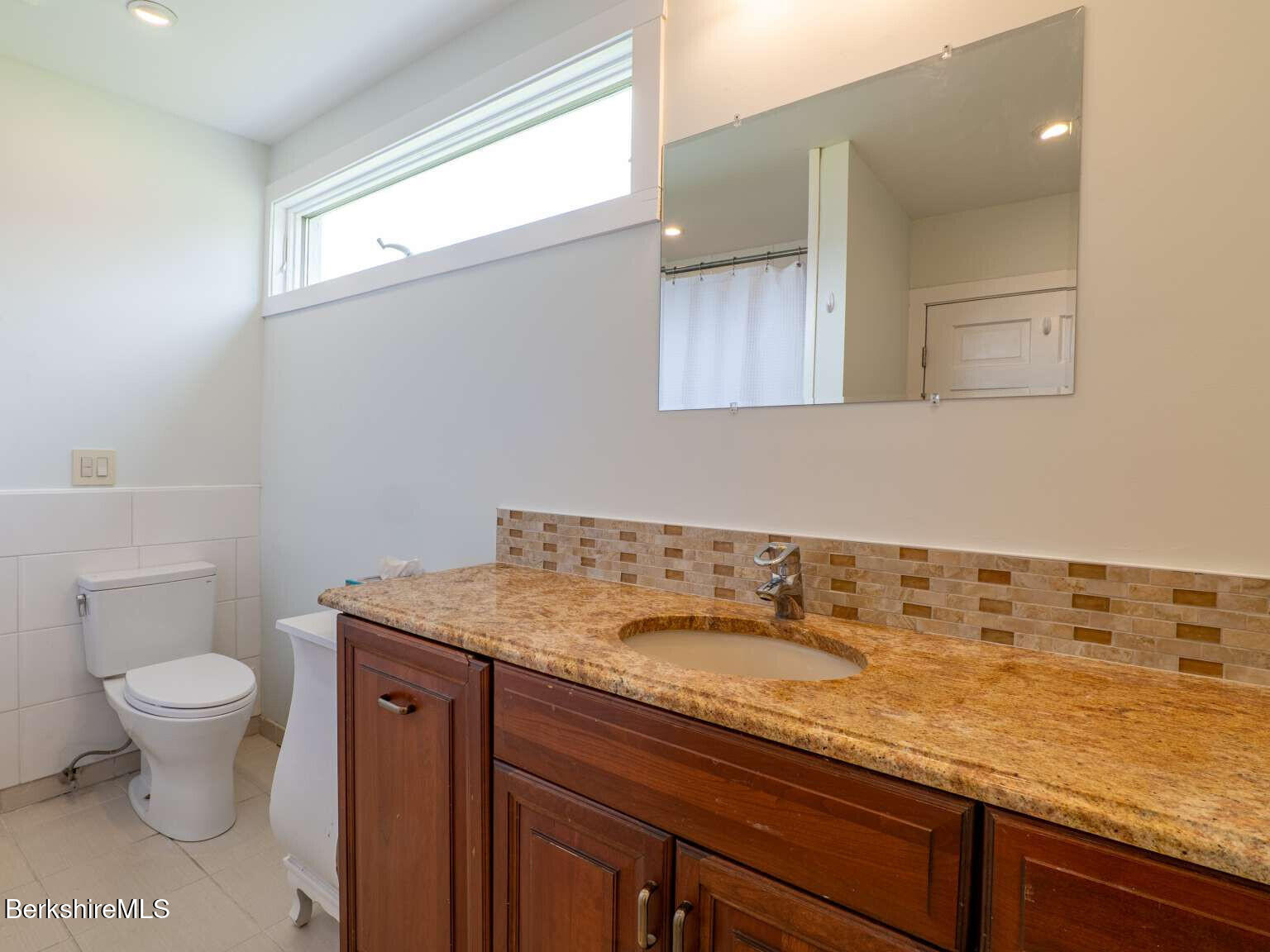 160 High Street Lee, MA 01238 - Photo 10 of 41 a bathroom with a granite countertop sink a toilet and a mirror