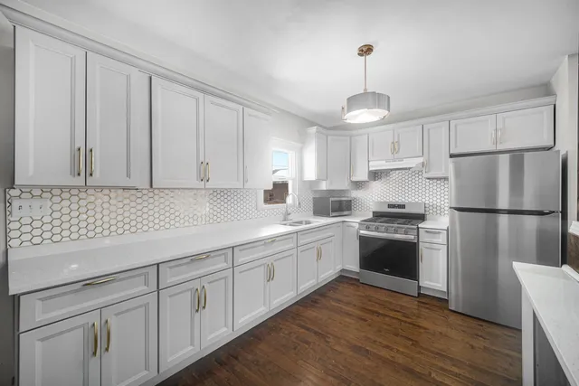 a kitchen with white cabinets stainless steel appliances and sink