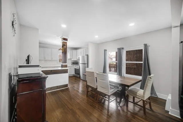 a kitchen with a dining table chairs and wooden floor