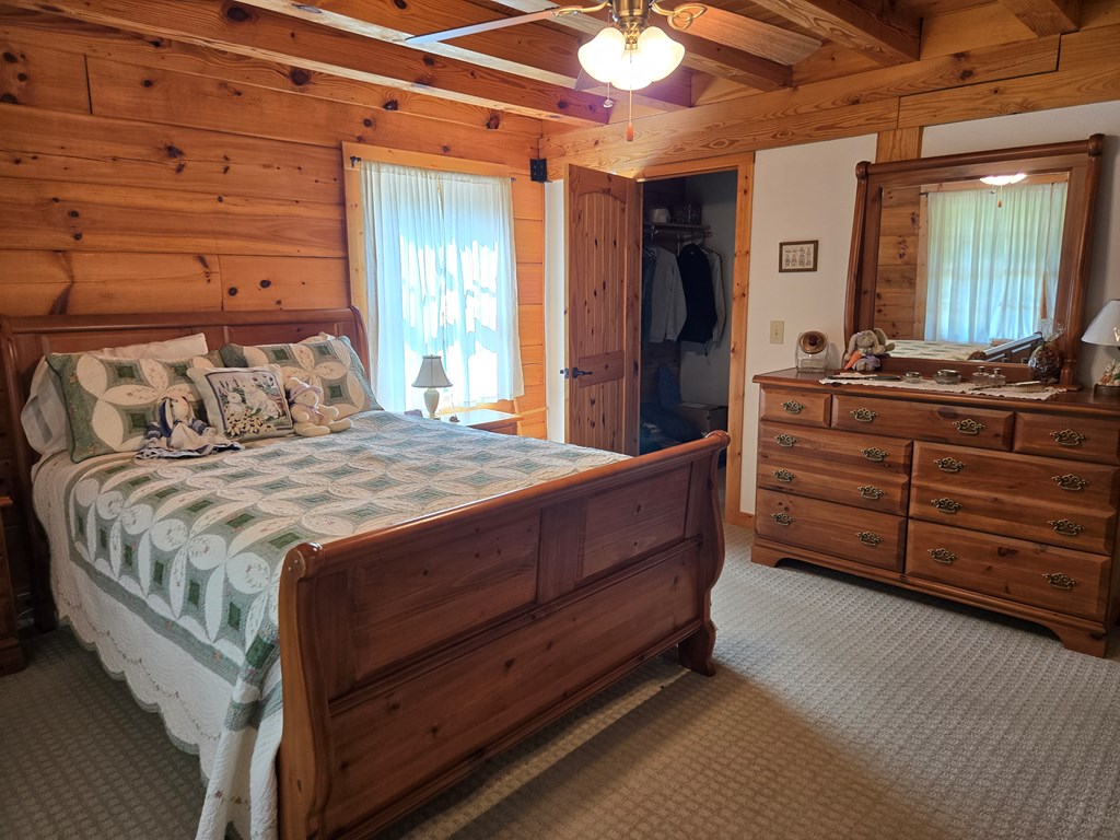 586 Laurel Haven Road Hayesville, NC 28904 - Photo 11 of 34 a bed sitting in a spacious bedroom next to a window and a dresser