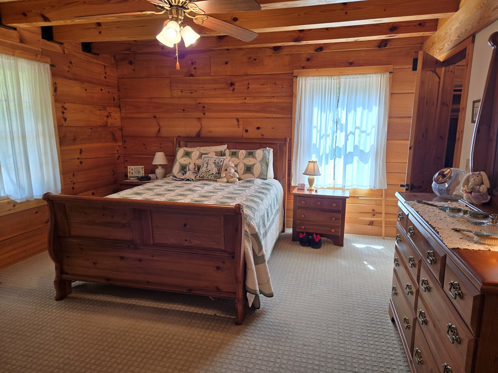 586 Laurel Haven Road Hayesville, NC 28904 - Photo 15 of 34 a bedroom with a bed and a chandelier