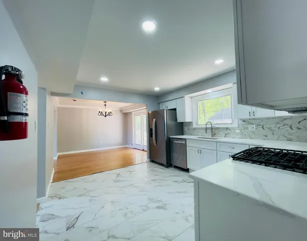 a large kitchen with kitchen island a sink stainless steel appliances and cabinets
