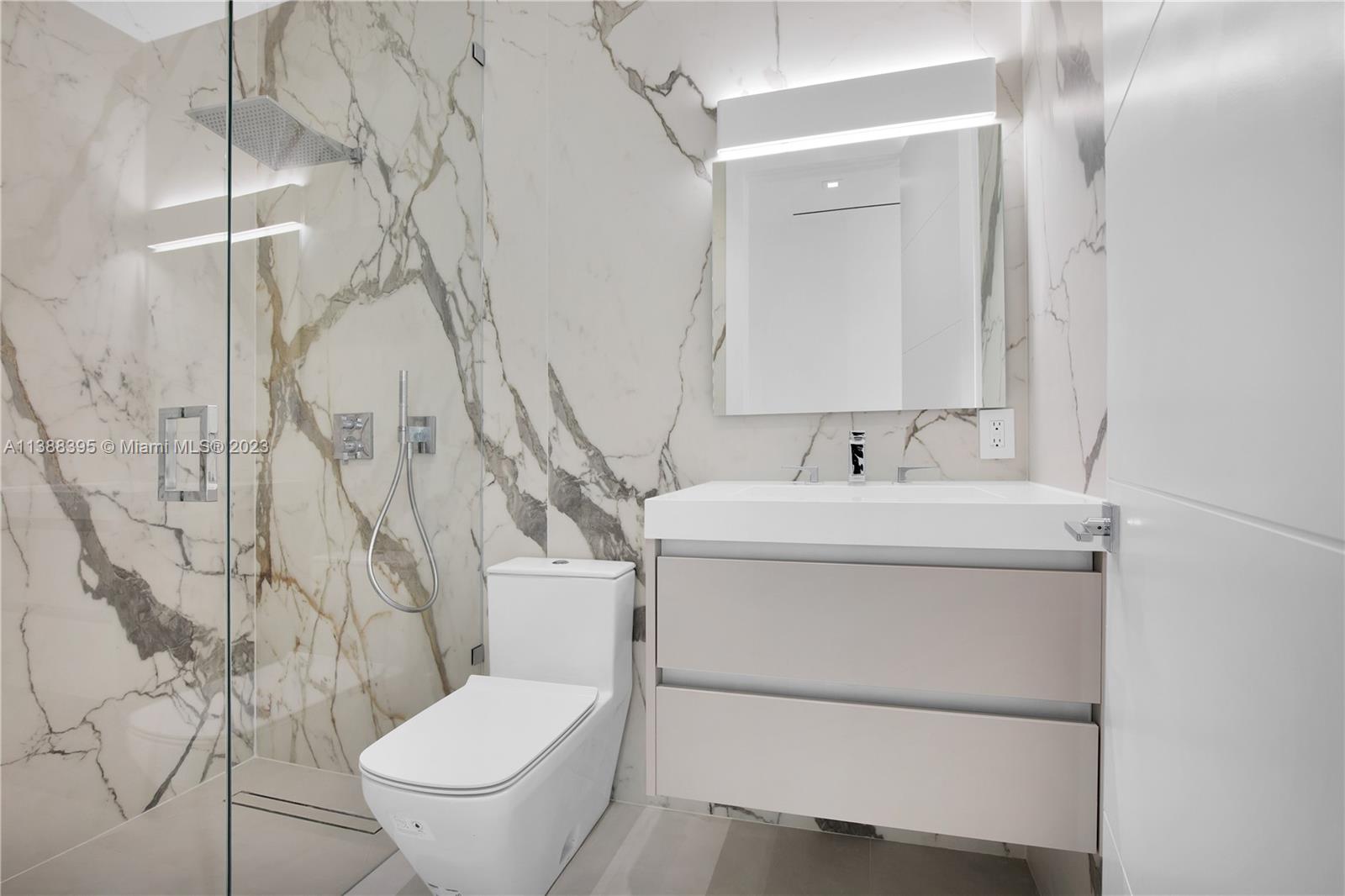 5630 Pine Tree Drive Miami Beach, FL 33140 - Photo 26 of 32 a bathroom with a toilet sink and mirror