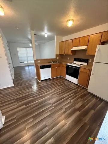 a kitchen with stainless steel appliances wooden floor and a counter top space