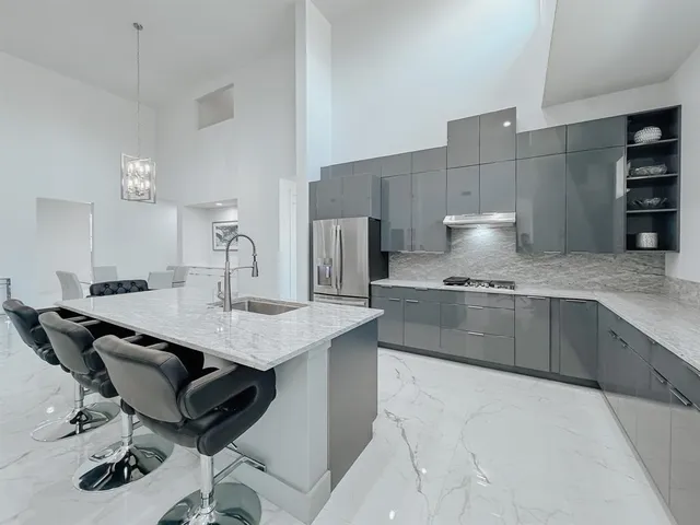 a kitchen with stainless steel appliances a sink a stove and a refrigerator