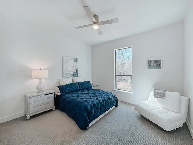 a bedroom with a bed couches and window