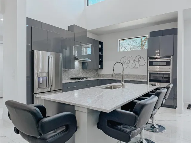 a kitchen with a table chairs sink and refrigerator