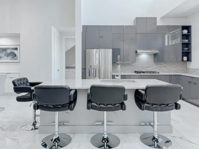 a kitchen with a dining table cabinets and chairs