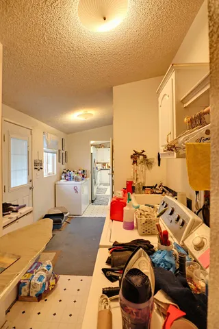 a view of a white house with a big yard plants and large trees