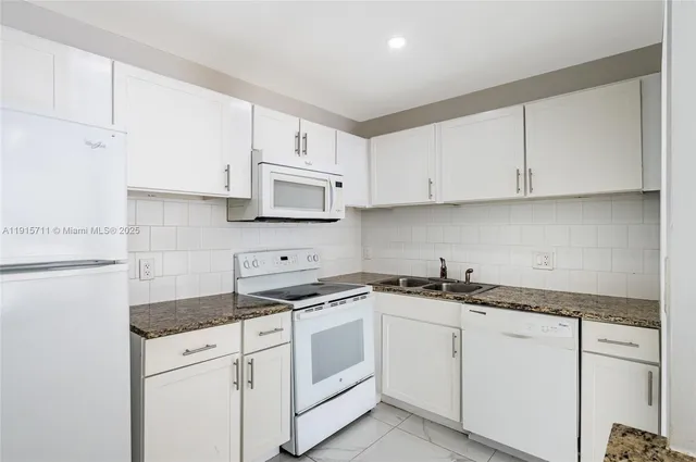 a kitchen with white cabinets sink and white appliances