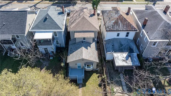 an aerial view of a house with yard and mountain view in back