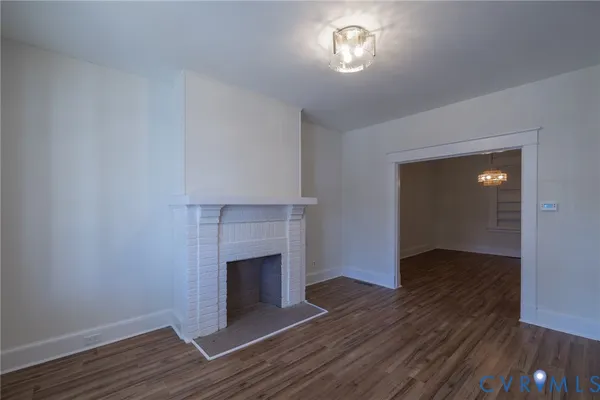 an empty room with wooden floor and staircase