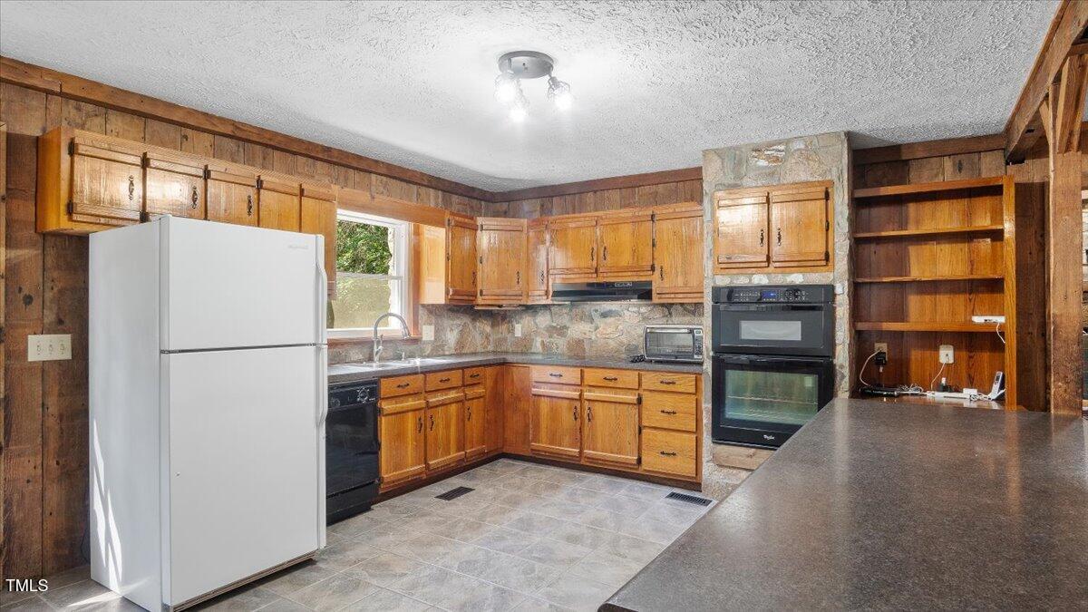424 Roy Carver Road Semora, NC 27343 - Photo 43 of 68 a kitchen with stainless steel appliances granite countertop a refrigerator and a stove top oven