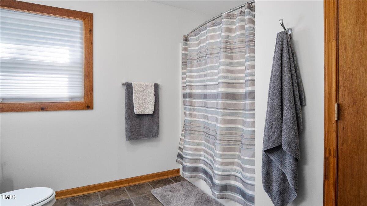 424 Roy Carver Road Semora, NC 27343 - Photo 45 of 68 a bathroom with a toilet and a shower curtain
